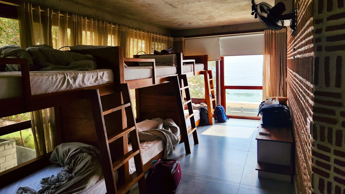Shared room with wooden bunk beds and tenants' luggage, a typical bedspace setup